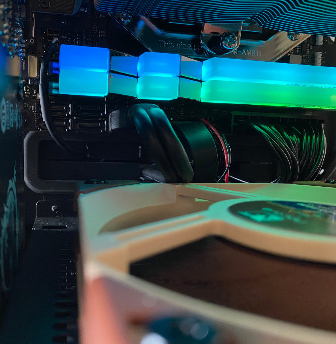 Internals of a custom PC showing a fan, wires, and RGB memory.
